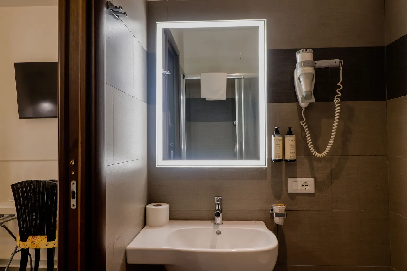 Bagno privato con specchio retroilluminato, doccia e set cortesia