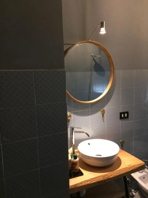 Bagno de Il Mulino con lavabo su piano in legno e specchio tondo