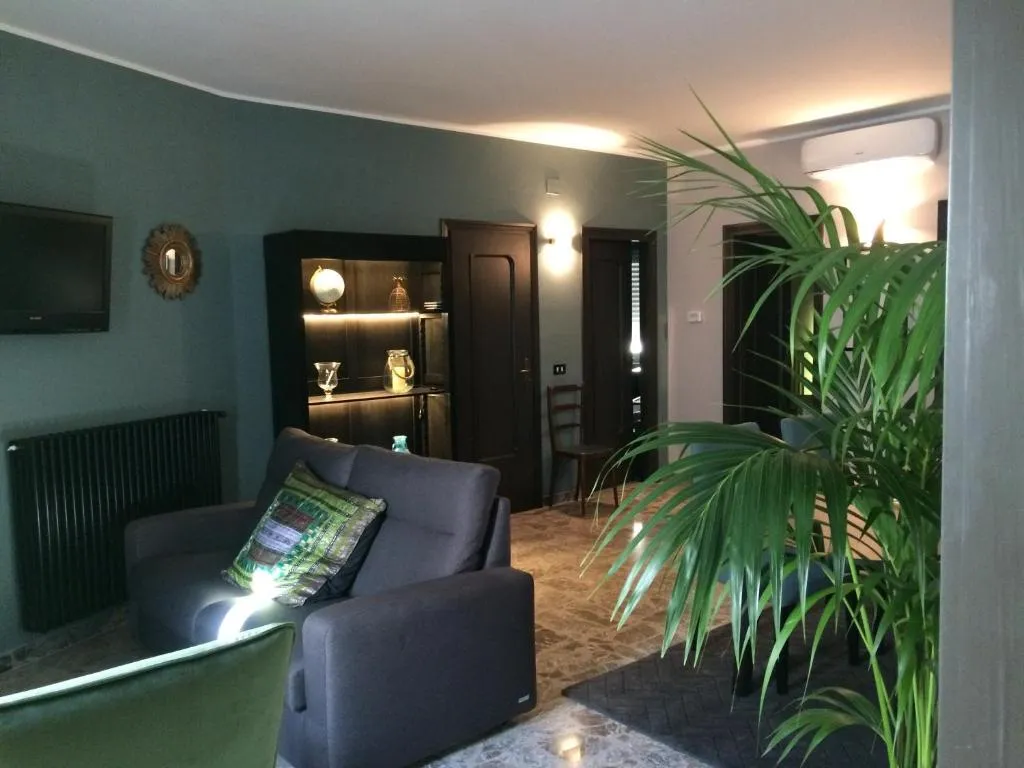 Il soggiorno de Il Mulino: pareti verdi, credenza illuminata e piante