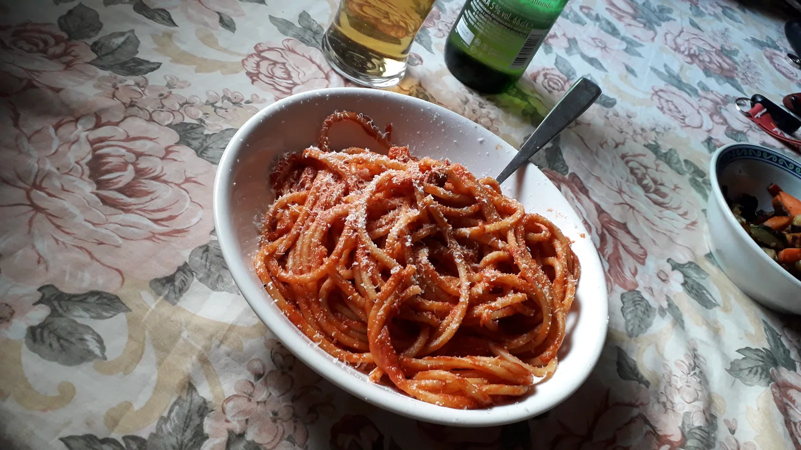Piatto di bucatini all'amatriciana a Roma: la pasta lunga condita con sugo di pomodoro, guanciale croccante e pecorino romano grattugiato