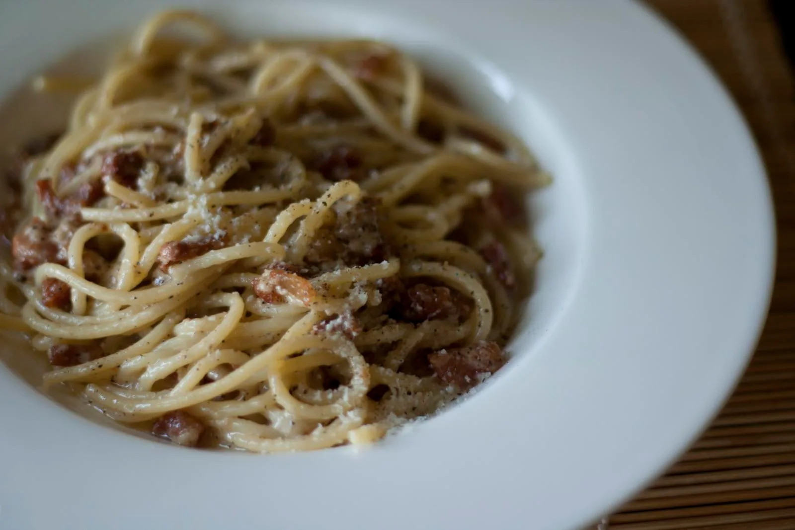 Piatto di pasta alla gricia a Roma: rigatoni con guanciale croccante e pecorino romano, la versione senza pomodoro che è la base dell'amatriciana