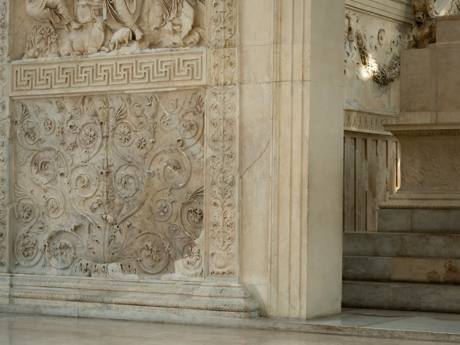 Dettaglio dei rilievi marmorei dell'Ara Pacis Augustae nel museo di Roma: i girali d'acanto e la cornice a greca accanto alla scalinata dell'altare augusteo