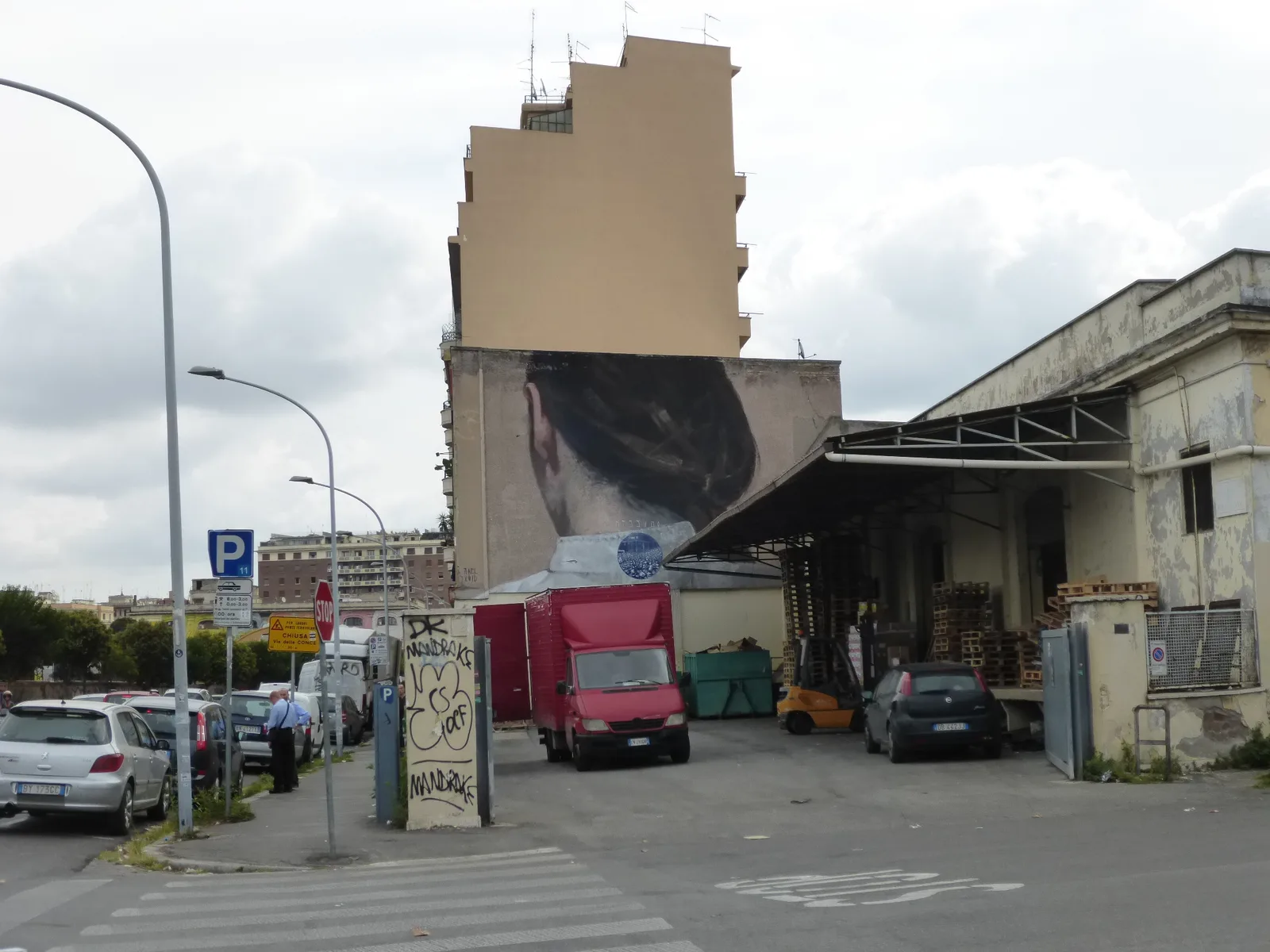 Un grande murale sulla facciata di un palazzo in Via del Porto Fluviale, nel rione Ostiense a Roma, esempio della street art che ricopre il quartiere