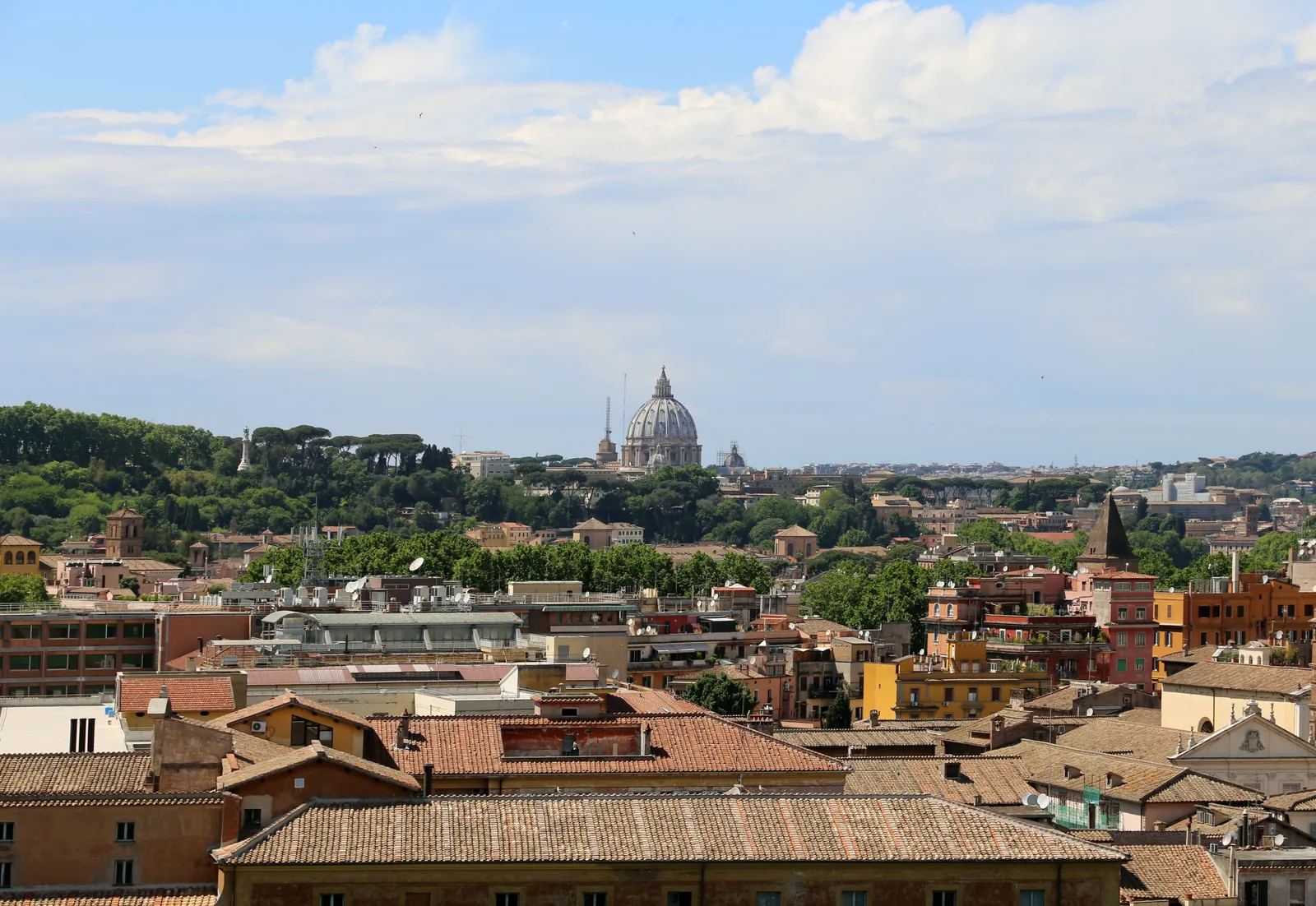 Veduta dal belvedere dell'Aventino verso il Tevere e la cupola di San Pietro, con la basilica di Santa Sabina e i tetti di Roma stesi sotto la collina