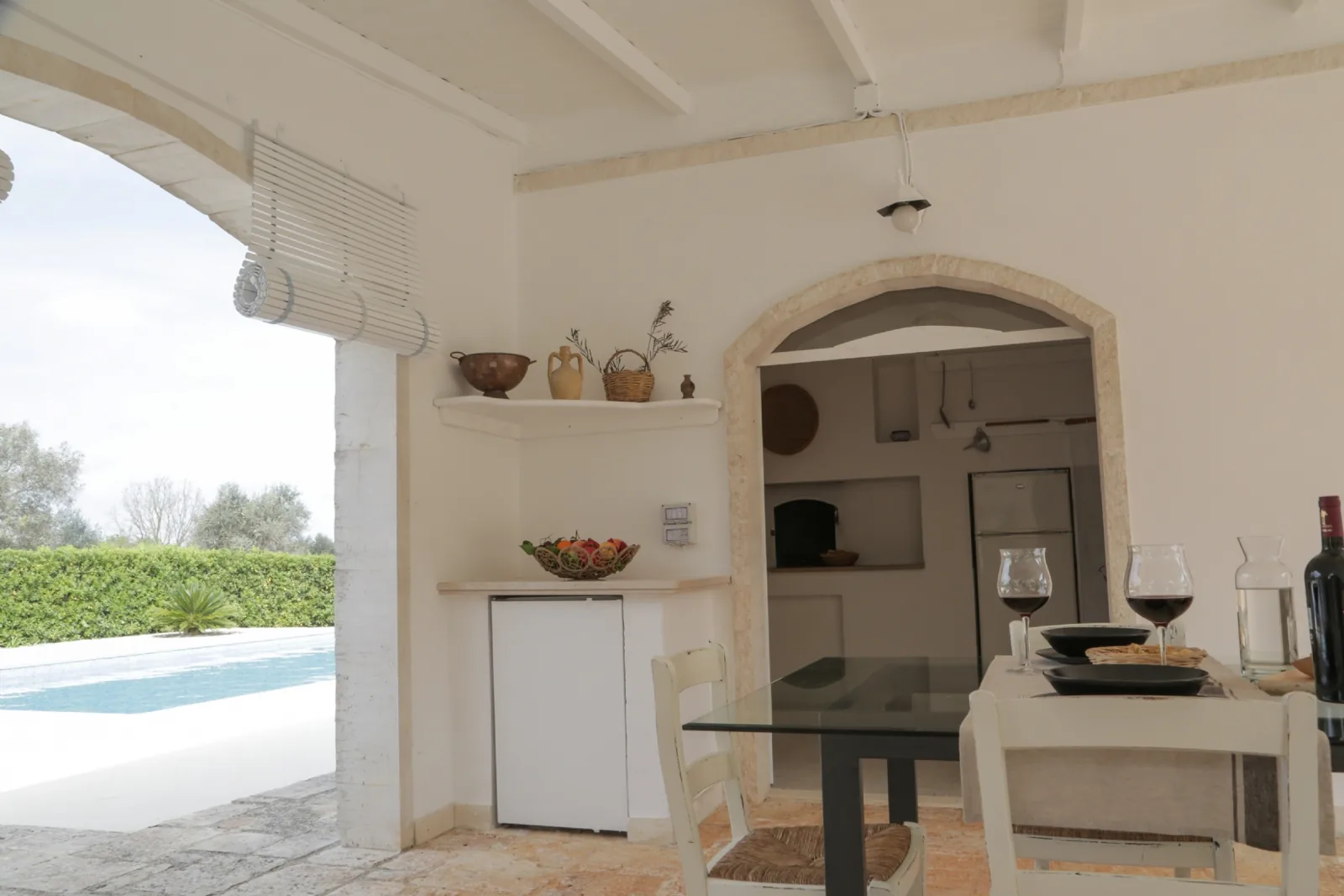 La veranda all'ombra con cucina in pietra e vista sulla piscina