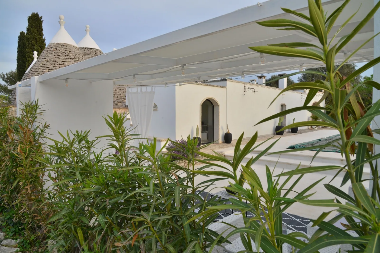 La veranda di Trullux all'imbrunire, tra gli oleandri
