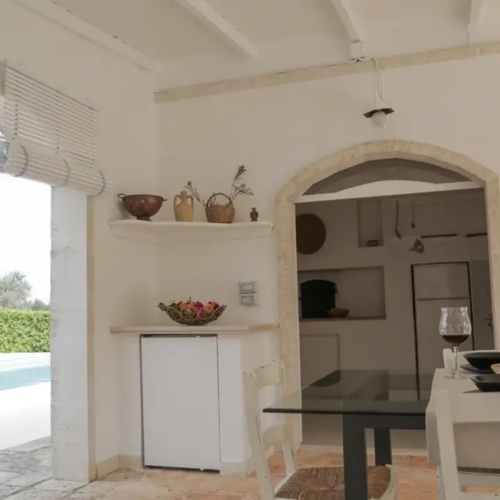 La veranda a la sombra con cocina de piedra y vista a la piscina